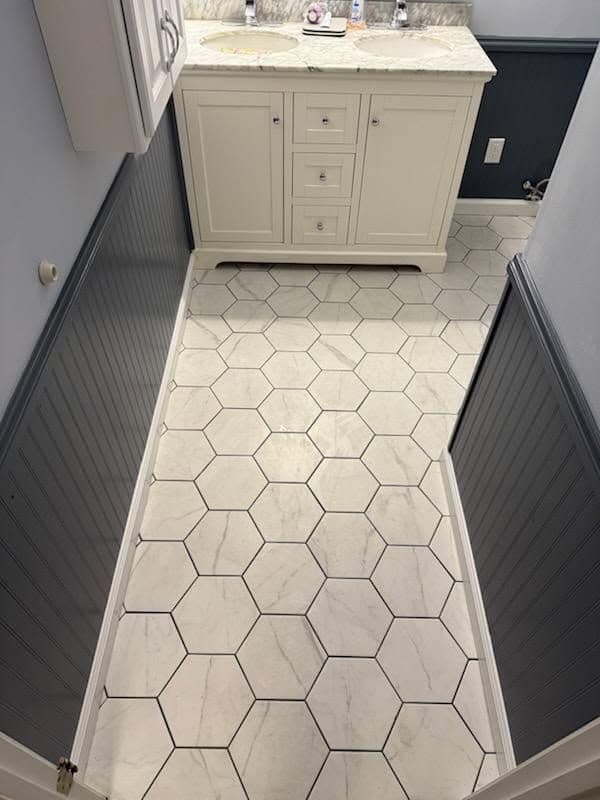 Elegant Bathroom Makeover with Hexagon Tiles and Dark Wainscoting image